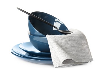 Photo of Stack of ceramic tableware with napkin and spoon isolated on white