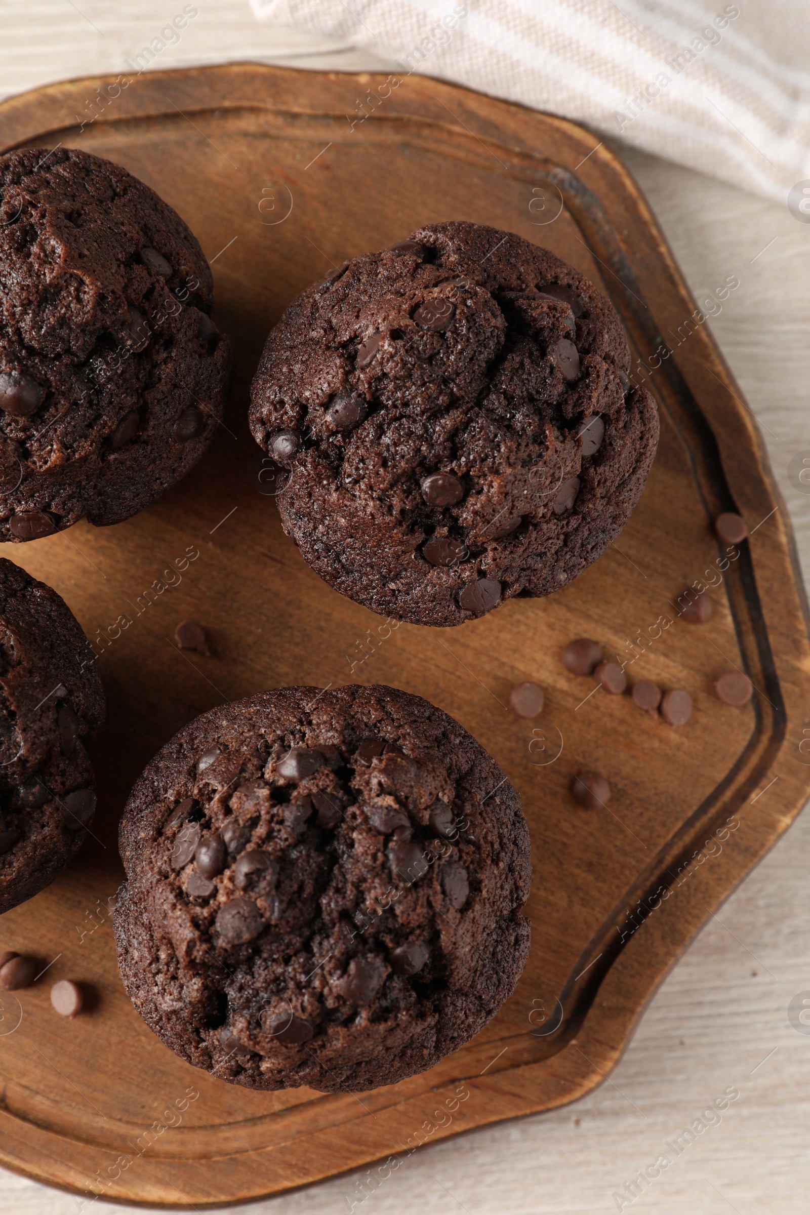 Photo of Delicious chocolate muffins on white wooden table, top view