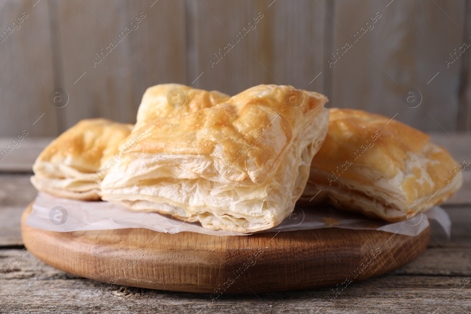 Photo of Delicious puff pastry on wooden table, closeup