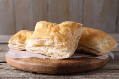 Delicious puff pastry on wooden table, closeup