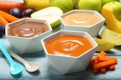 Photo of Healthy baby food and fresh ingredients on grey wooden table