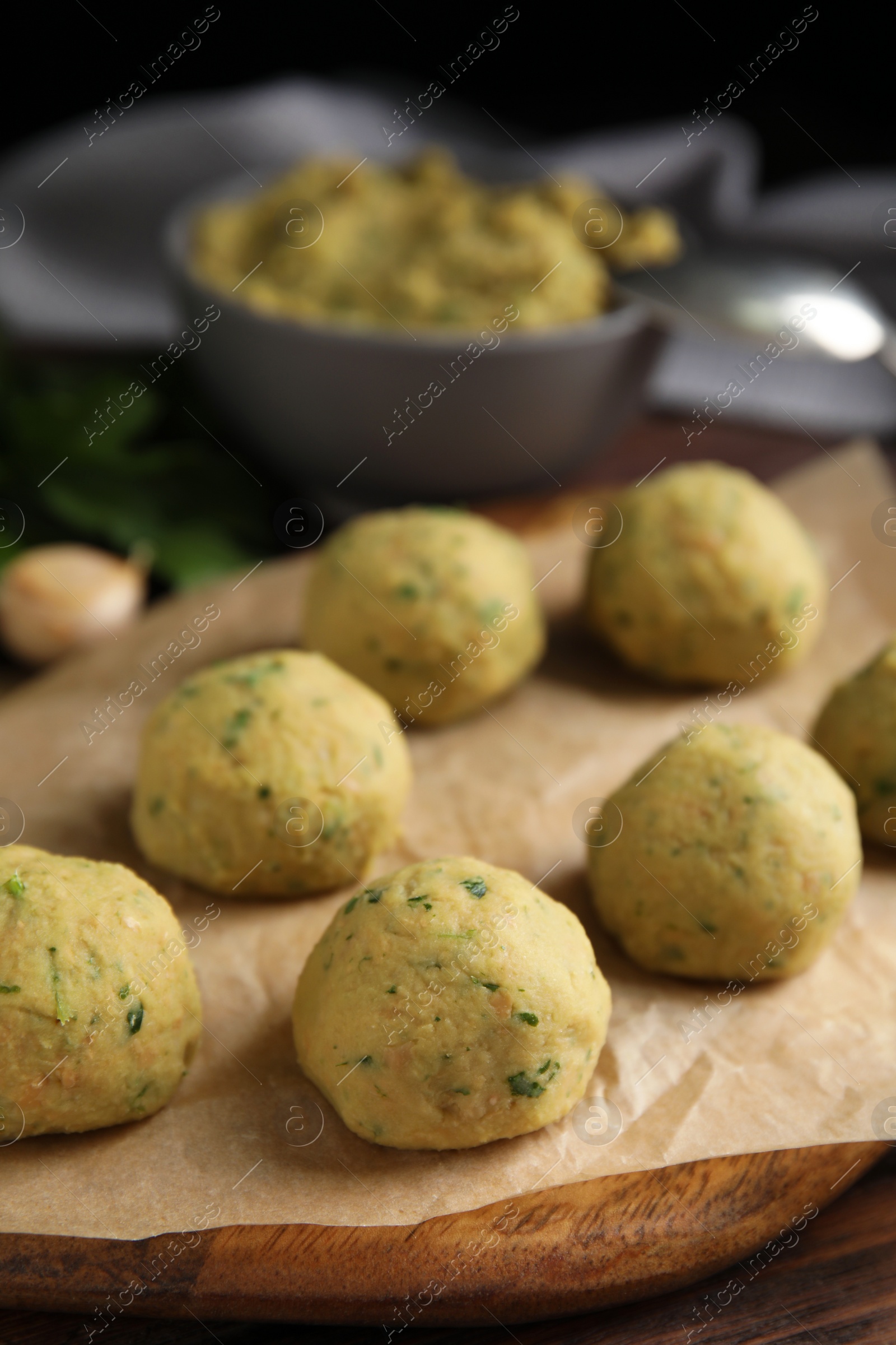 Photo of Raw falafel balls on wooden board, closeup