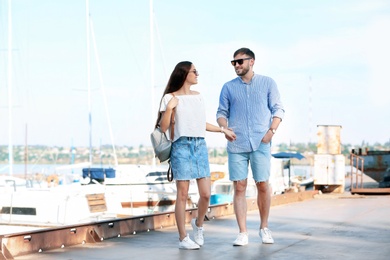 Photo of Young hipster couple in jean clothes on pier