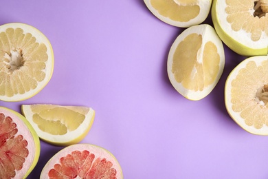 Photo of Fresh cut pomelo fruits on lilac background, flat lay. Space for text