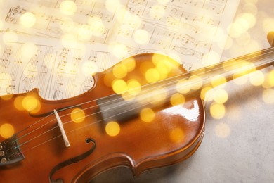 Christmas and New Year music. Violin on music sheets, bokeh effect