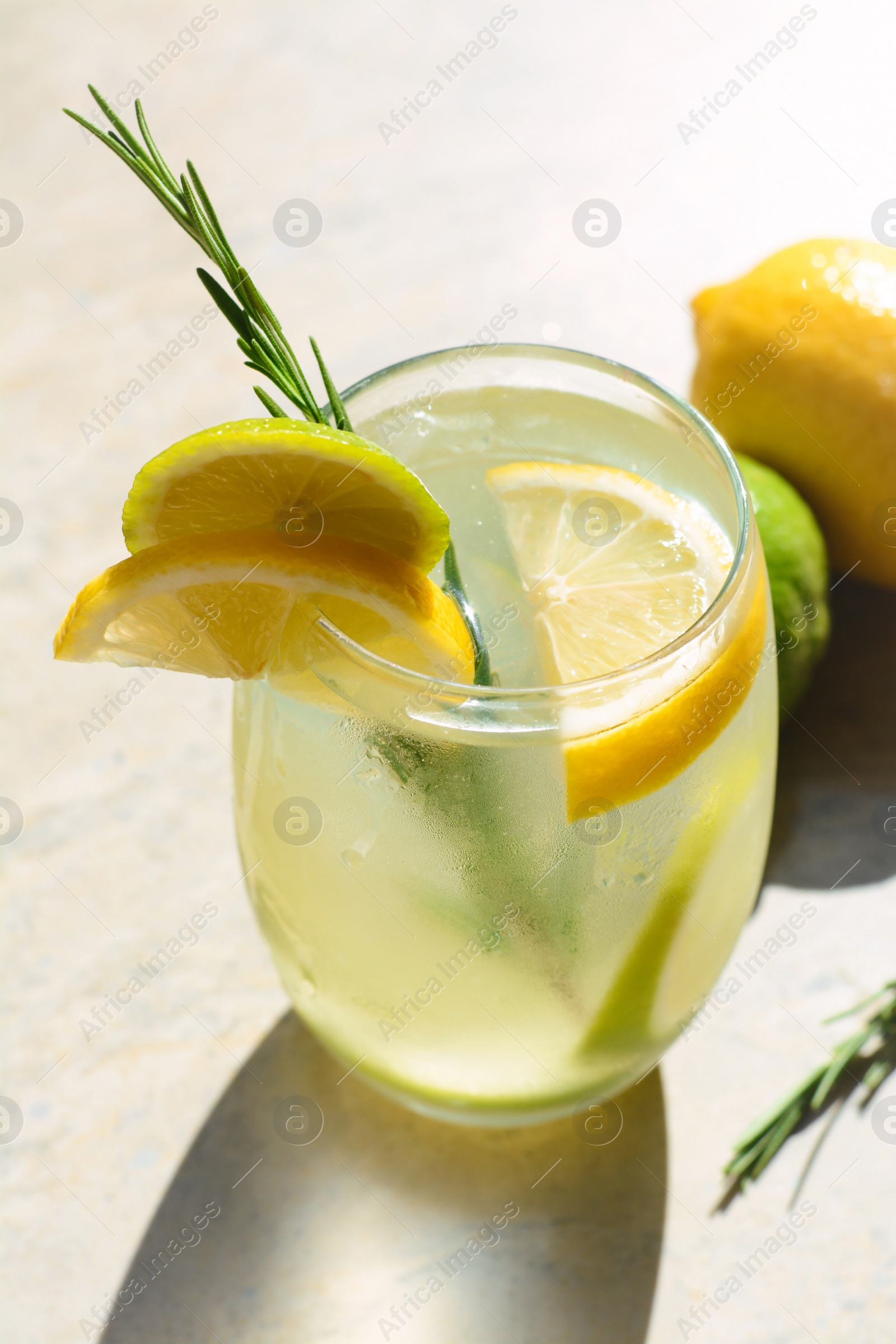 Photo of Tasty refreshing lemonade and ingredients on light table. Summer drink