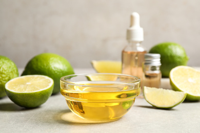 Photo of Lime essential oil and cut citrus fruits on light table