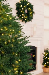 Beautiful Christmas tree with glowing fairy lights in room