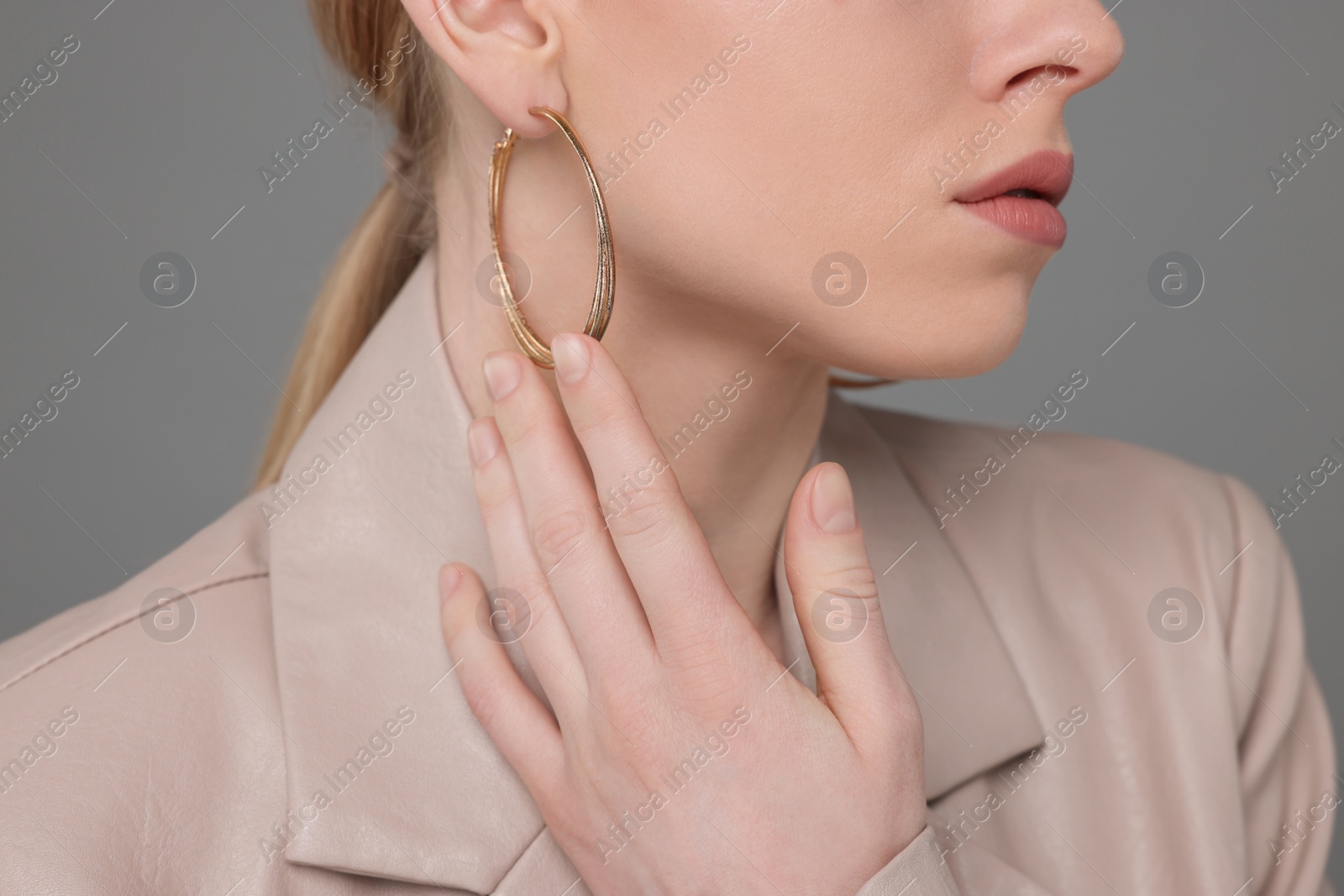 Photo of Woman with elegant earrings on gray background, closeup