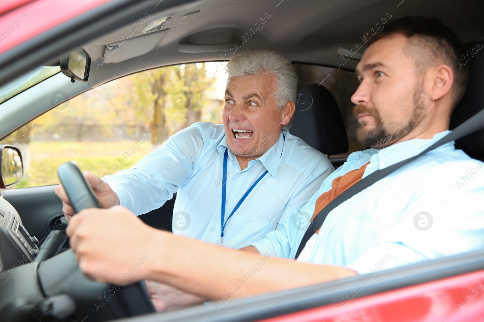 Photo of Man and instructor in car. Fail driving license exam