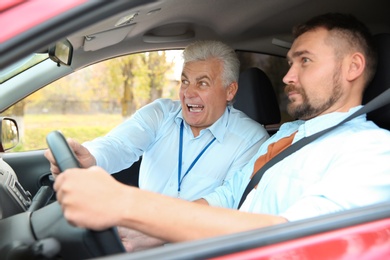 Man and instructor in car. Fail driving license exam