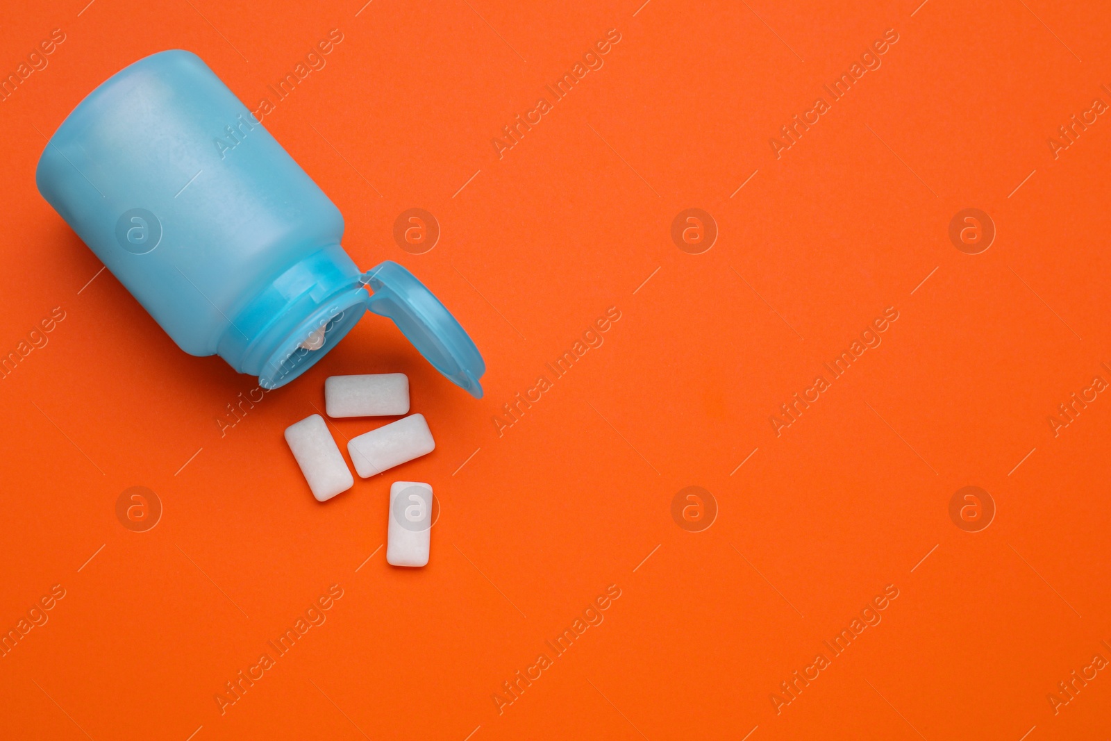 Photo of Jar with chewing gums on orange background, flat lay. Space for text