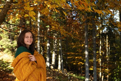 Portrait of beautiful young woman in autumn forest, space for text