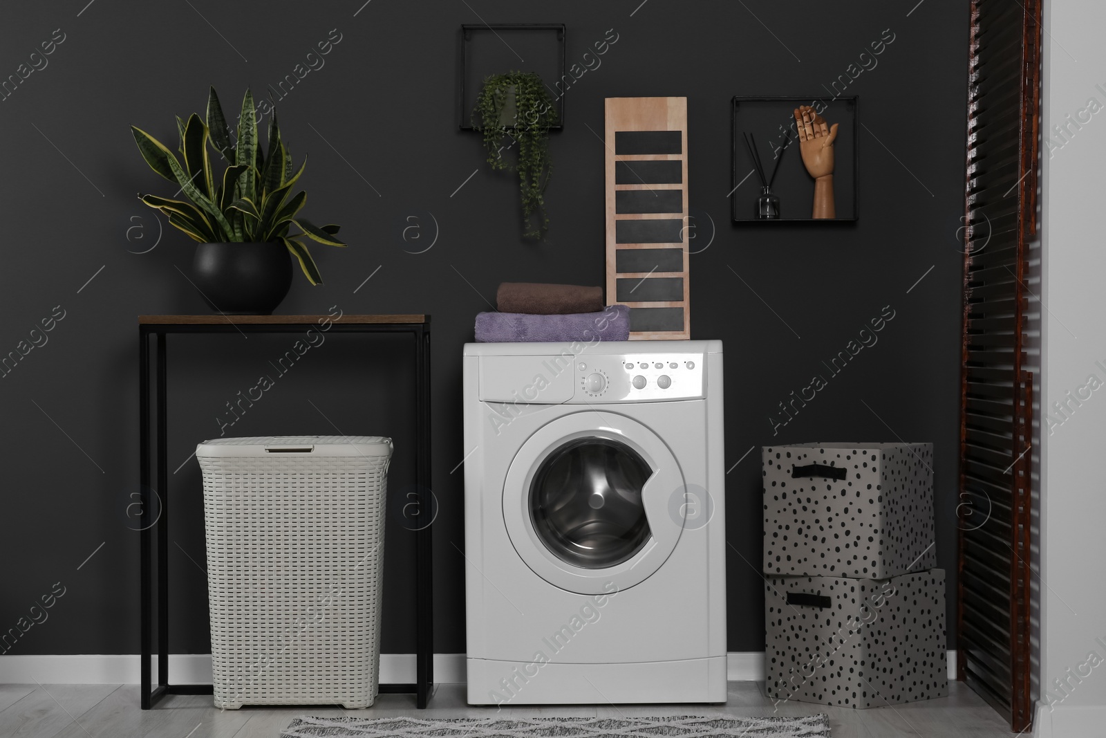 Photo of Stylish laundry room with washing machine. Interior design
