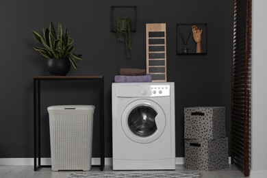 Photo of Stylish laundry room with washing machine. Interior design