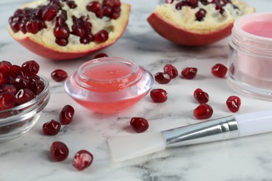 Photo of Homemade cosmetic product and fresh pomegranate on white marble table. DIY beauty recipe