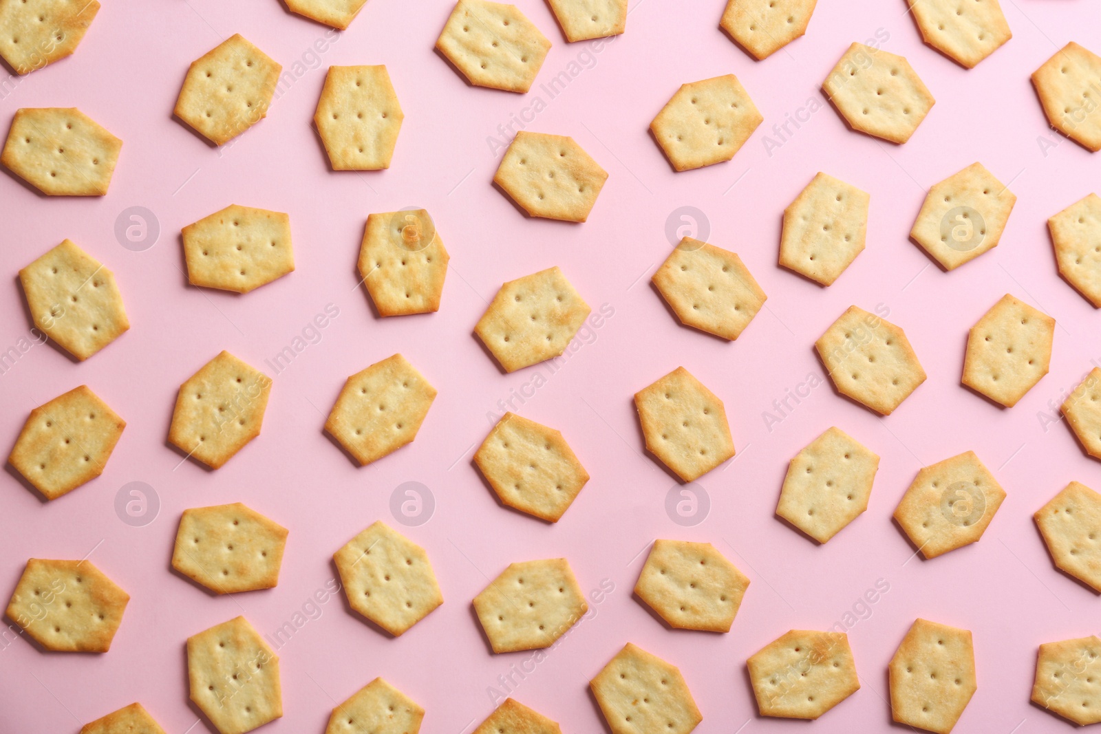Photo of Delicious crackers on pink background, flat lay