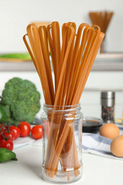 Photo of Uncooked buckwheat noodles and ingredients on white kitchen table