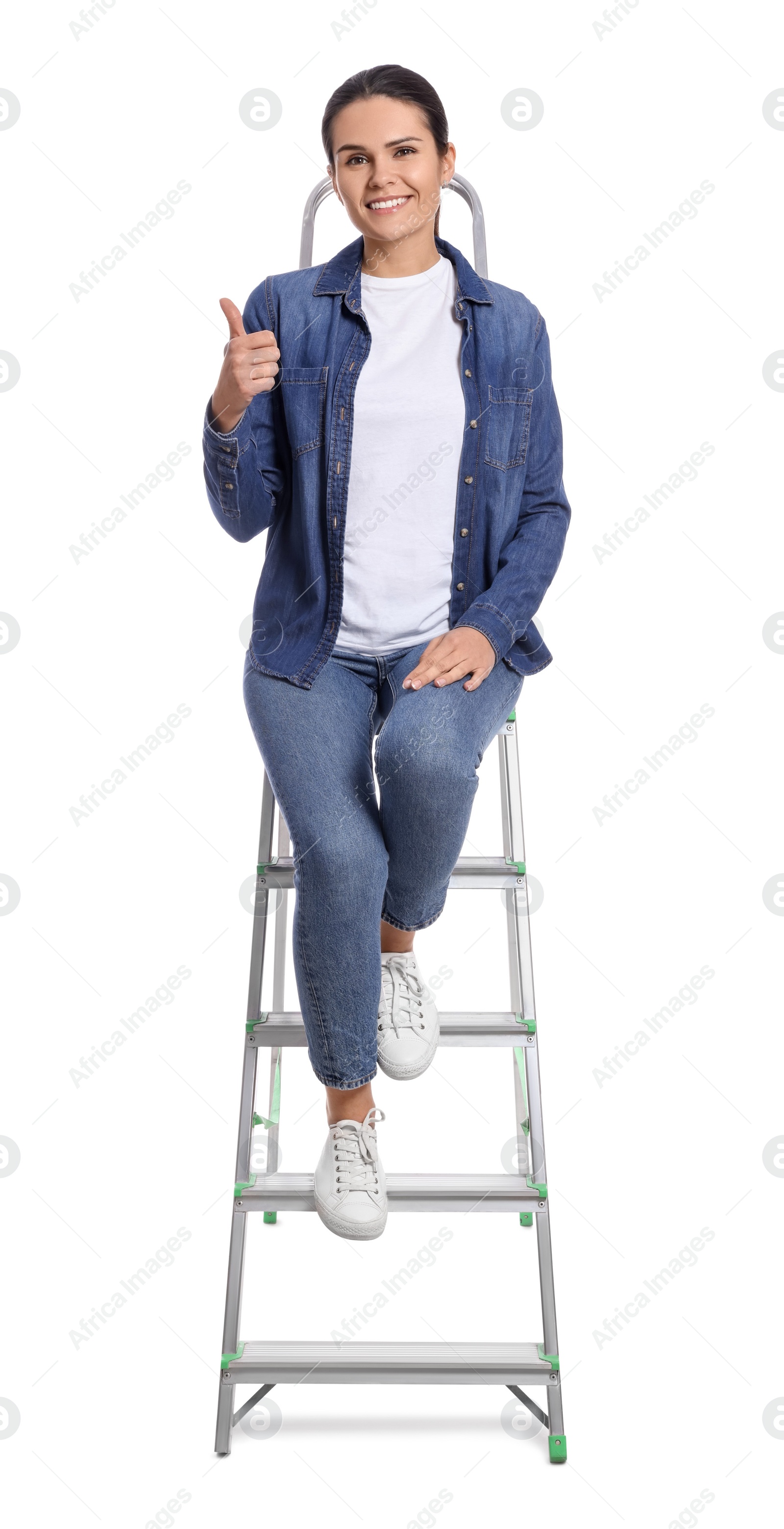 Photo of Young woman sitting on metal ladder against white background