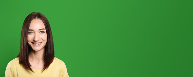 Image of Chroma key compositing. Beautiful young woman smiling against green screen