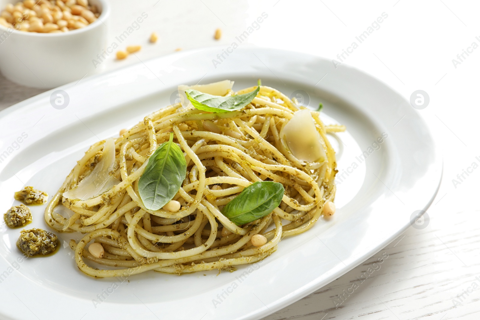 Photo of Plate with delicious basil pesto pasta on table