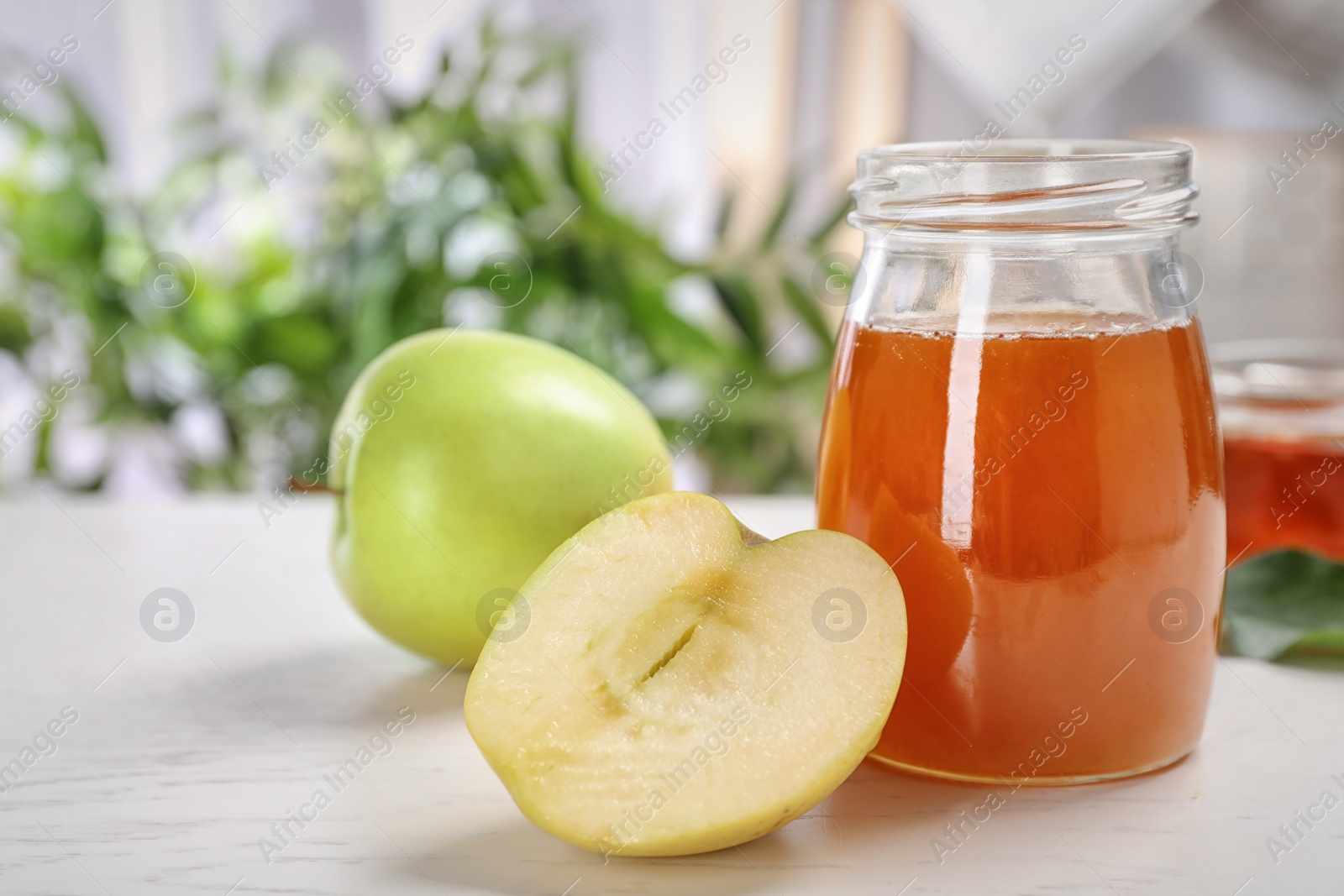 Photo of Jar of honey and apples on light table