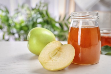 Photo of Jar of honey and apples on light table