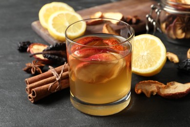 Photo of Delicious compote with dried apple slices and ingredients on black table