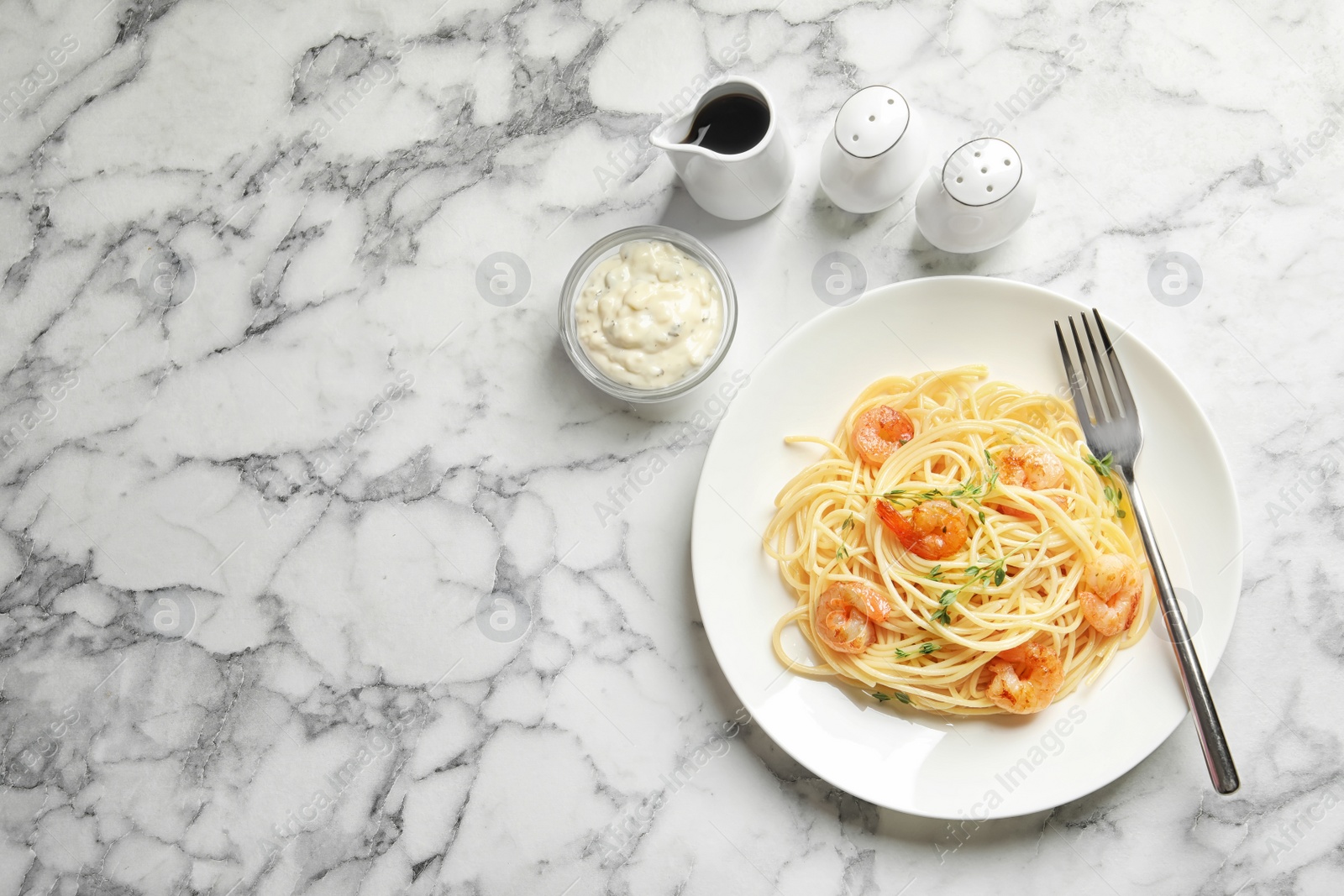 Photo of Plate with spaghetti and shrimps on light background, top view