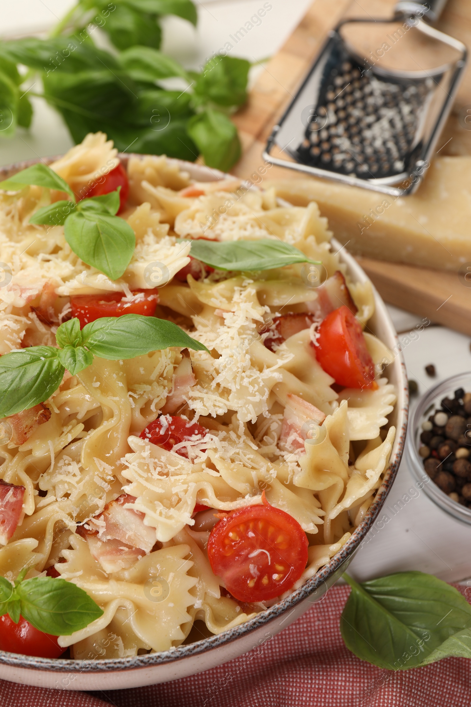 Photo of Plate of delicious pasta with tomatoes, basil and parmesan cheese on table, closeup