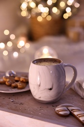 Photo of Cup of tasty hot drink and cookies on wooden table. Christmas atmosphere