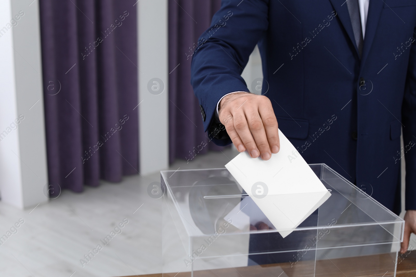 Photo of Man putting his vote into ballot box at polling station, closeup. Space for text