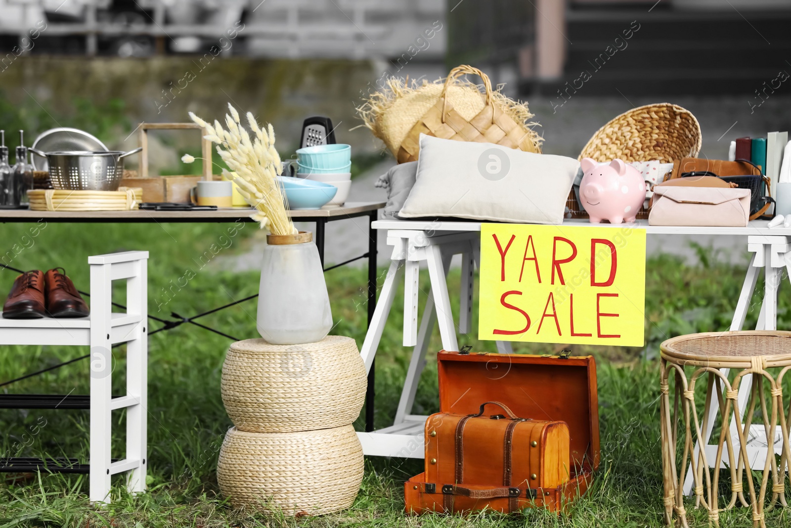 Photo of Table with different stuff and sign Yard sale outdoors