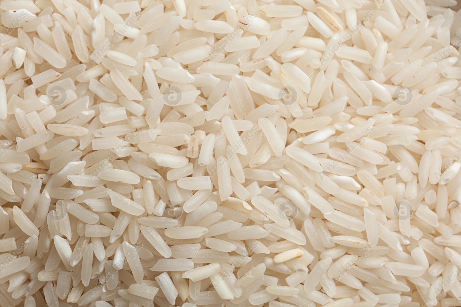 Photo of Raw long grain rice as background, closeup view