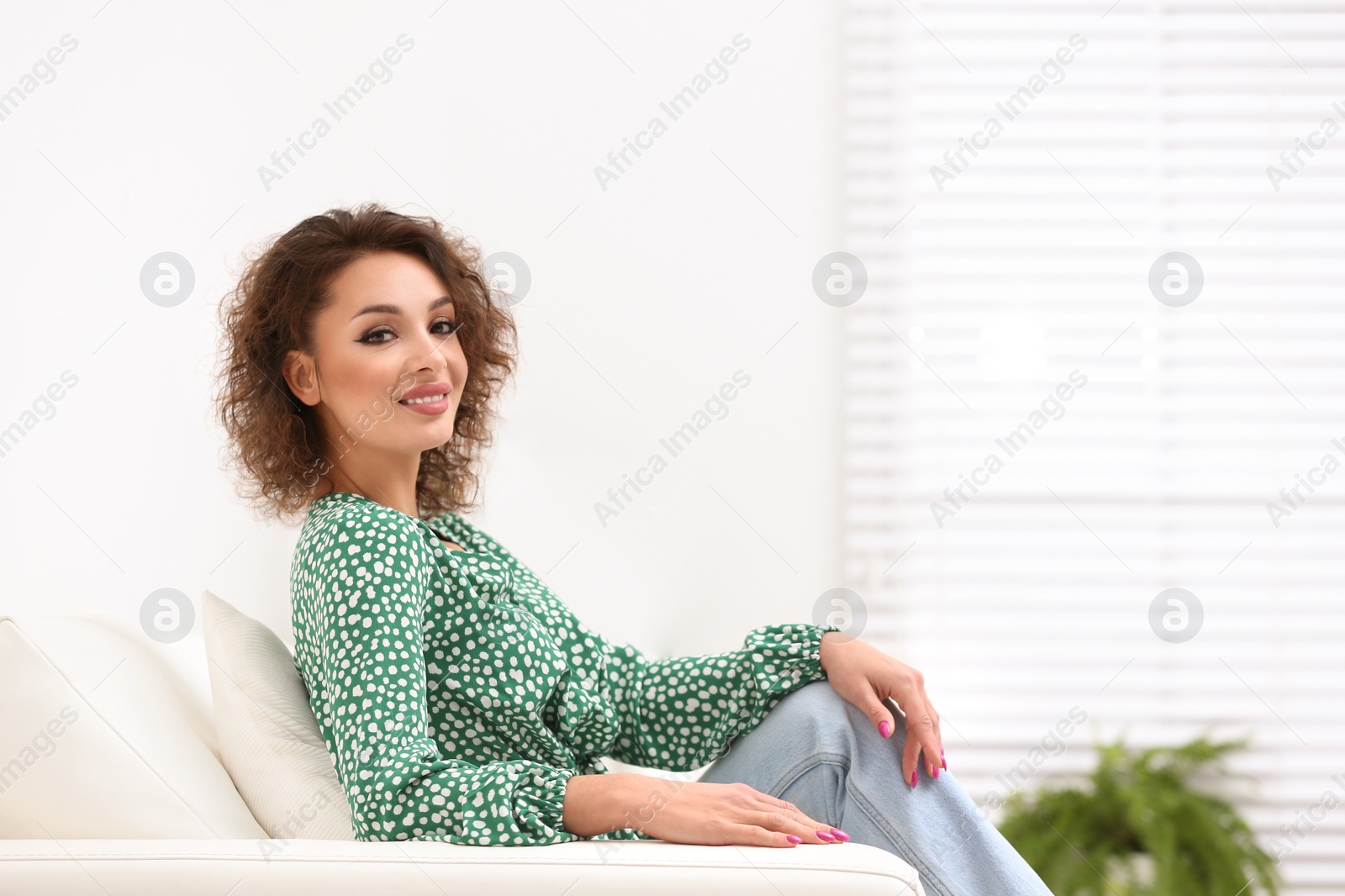 Photo of Beautiful woman in casual outfit on sofa indoors