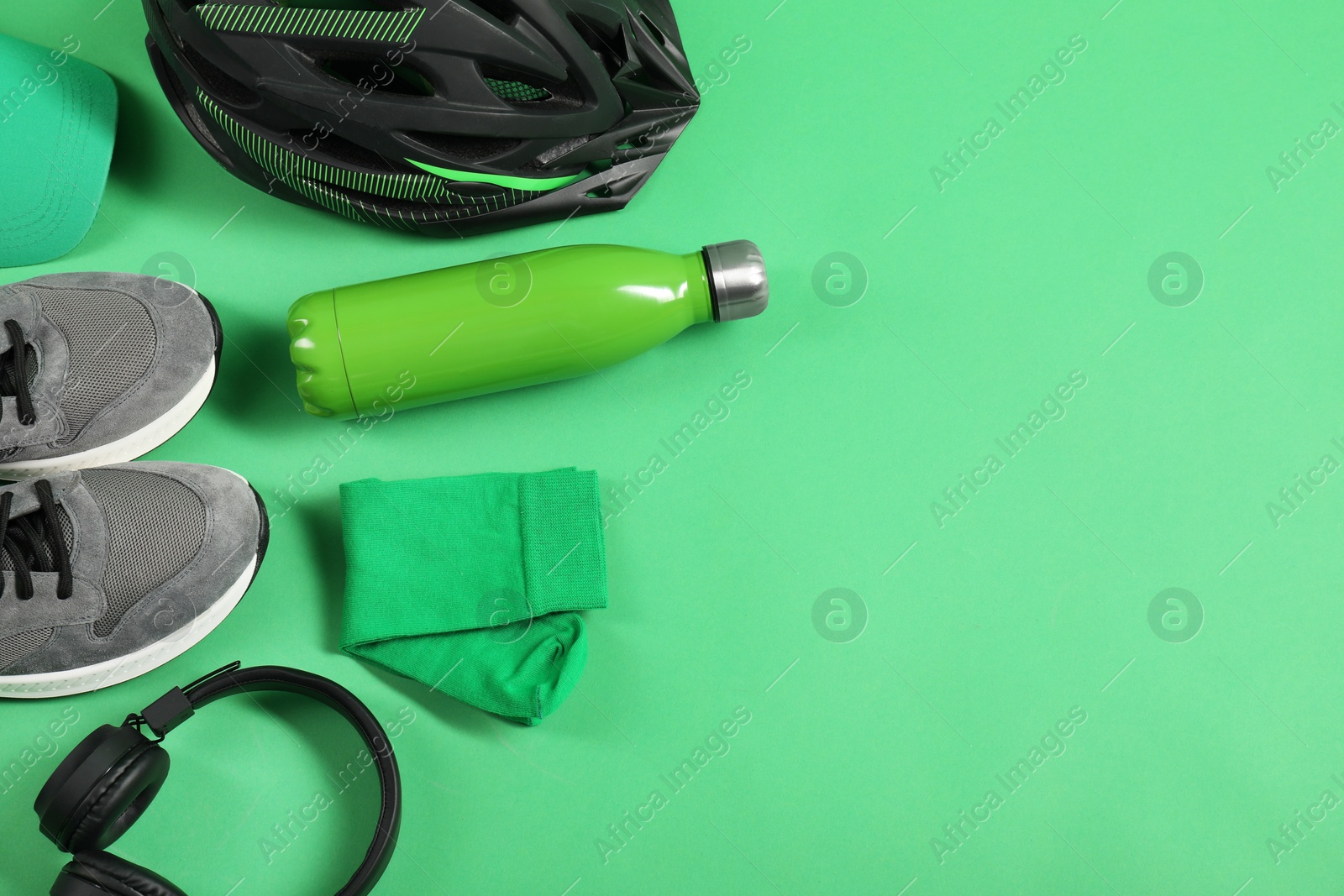 Photo of Different sports equipment on green background, flat lay. Space for text