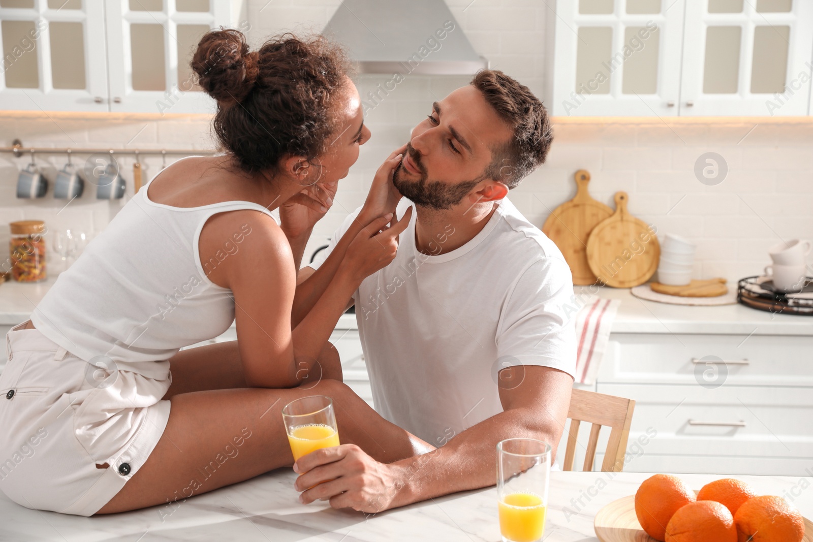 Photo of Lovely couple enjoying time together during breakfast at table in kitchen