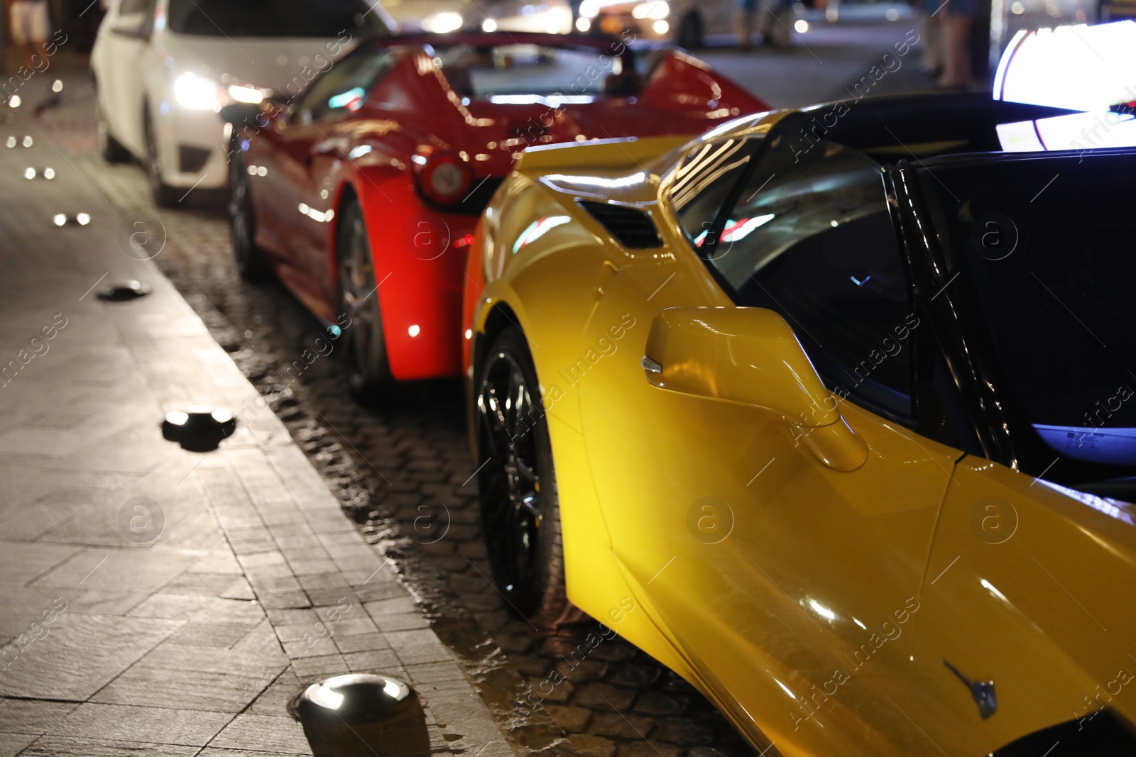 Photo of DUBAI, UNITED ARAB EMIRATES - NOVEMBER 03, 2018: Luxury cars on city street at night