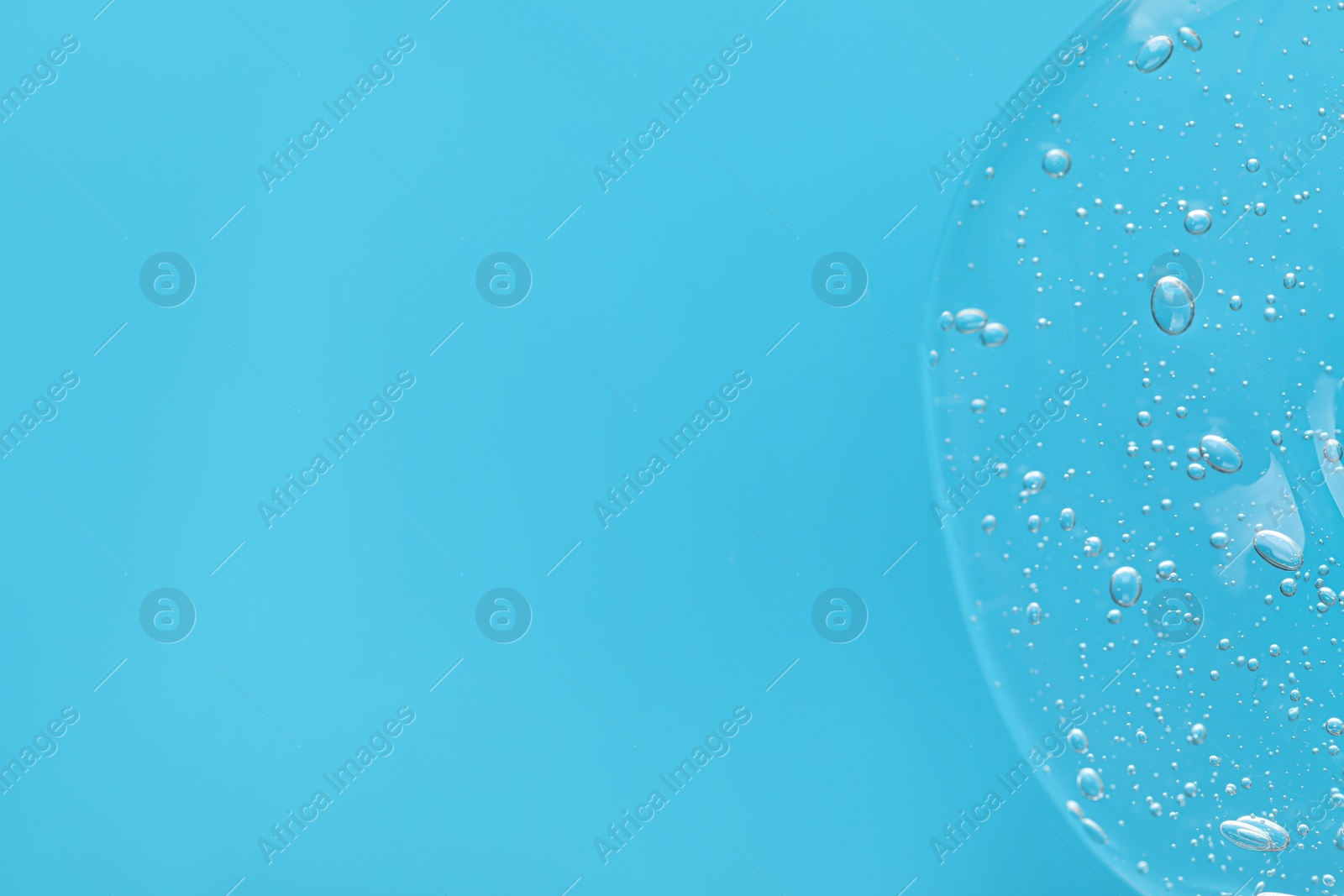 Photo of Sample of cleansing gel on light blue background, top view with space for text. Cosmetic product