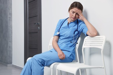 Exhausted doctor resting on chair in hospital