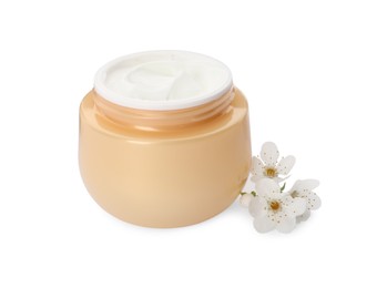 Photo of Face cream in jar and flowers on white background