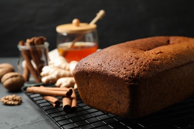 Delicious gingerbread cake and ingredients on cooling rack, space for text