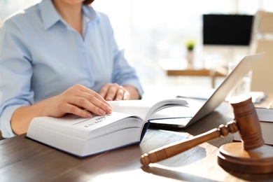 Female lawyer working at table in office