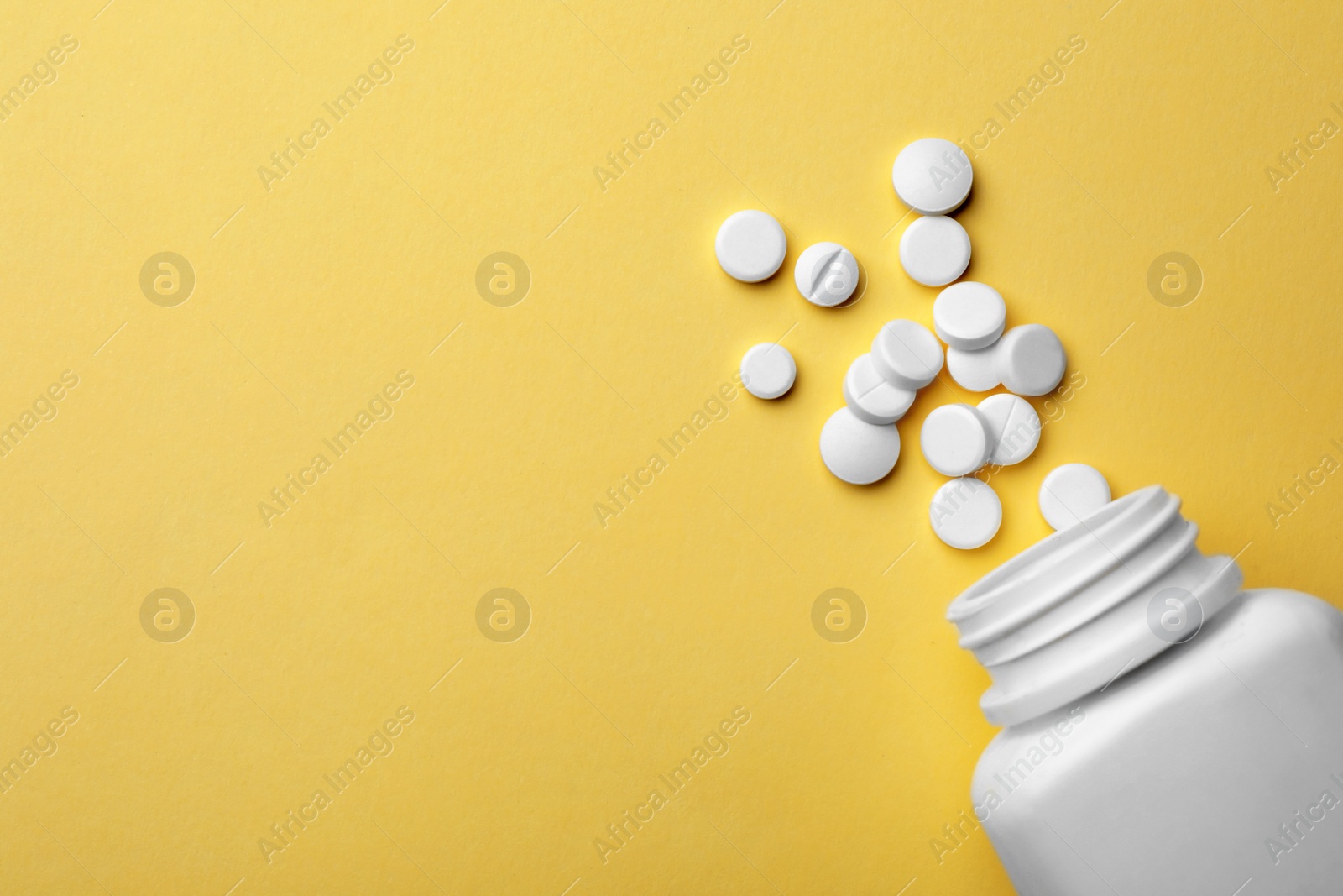 Photo of Bottle with different pills on color background, flat lay. Space for text