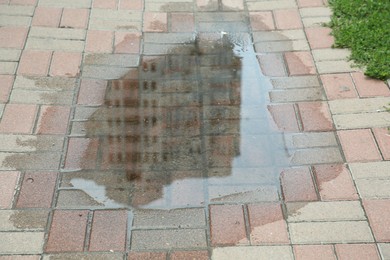 Photo of Puddle after rain on street tiles outdoors