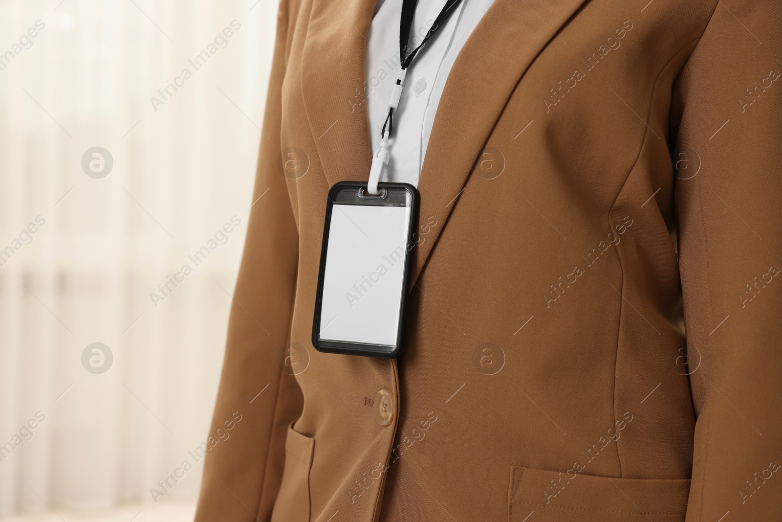 Photo of Woman with blank badge indoors, closeup. Space for text