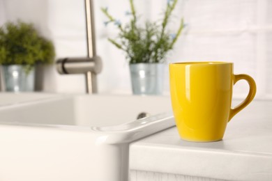 Photo of One ceramic mug on light countertop in kitchen, space for text