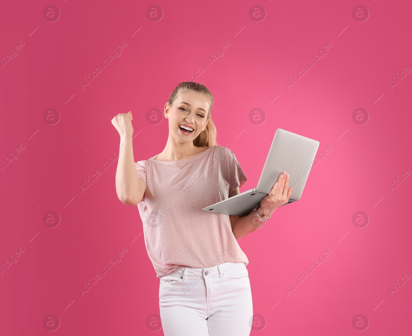 Photo of Portrait of young woman with laptop on pink background