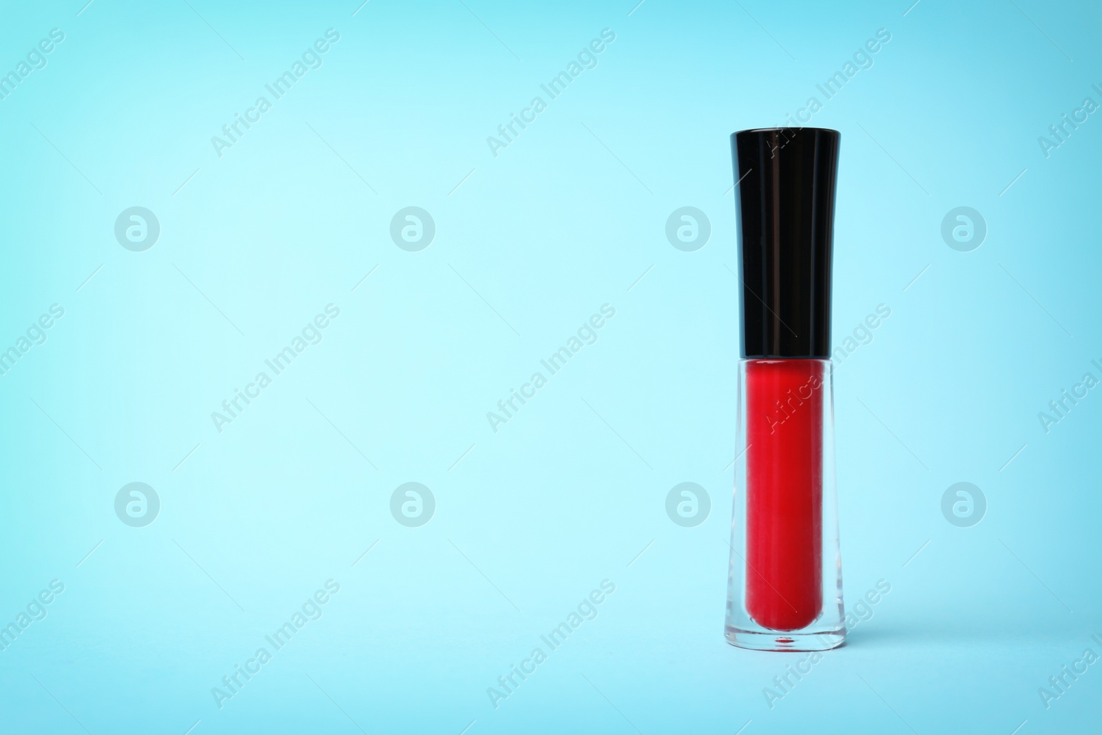 Photo of Beautiful lip gloss on color background