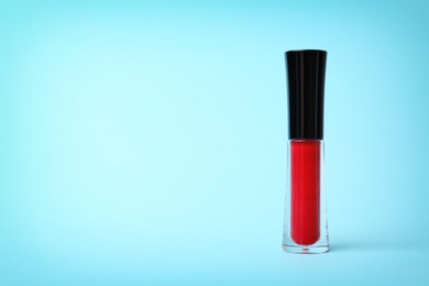 Beautiful lip gloss on color background